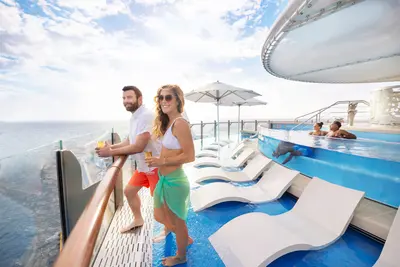 Couple with drinks on Suite Deck