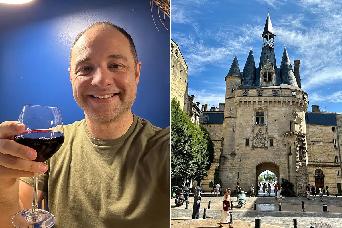 Matt drinking wine next to photo of landmark