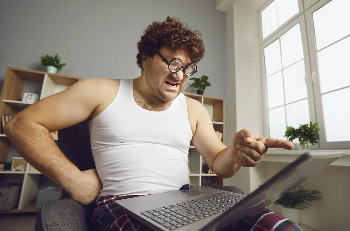 man points finger at laptop screen