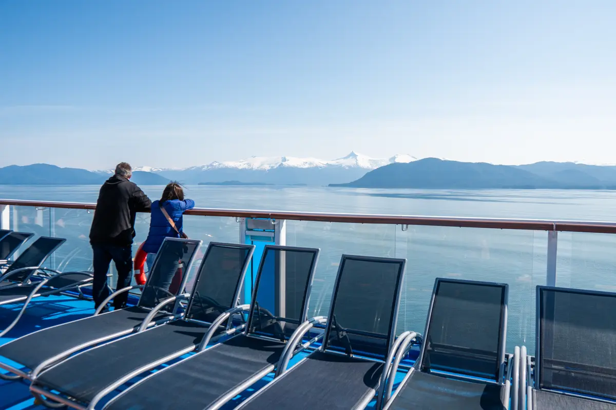 a couple watching the views of Alaska from the pool deck