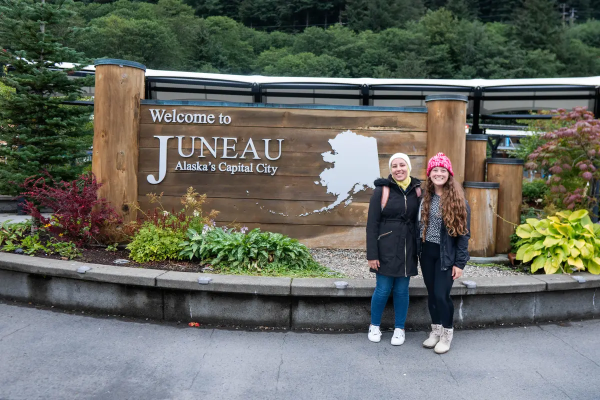 Two girls standing in front of Juneau sign in Juneau, Alaska