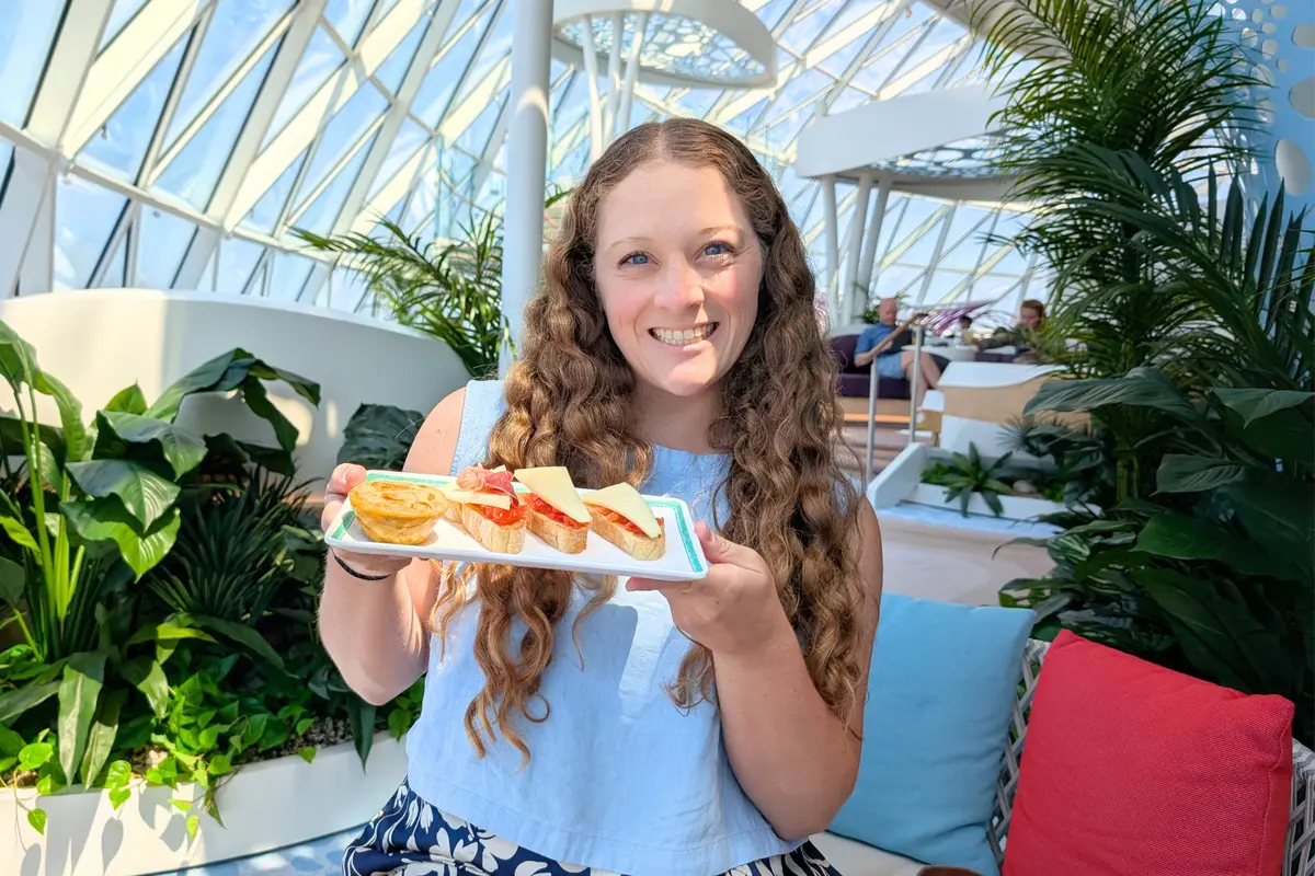 Jenna smiling with a plate of tapas on Legend of the Seas