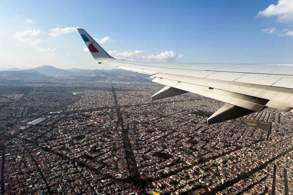 Airplane wing with Mexico City below